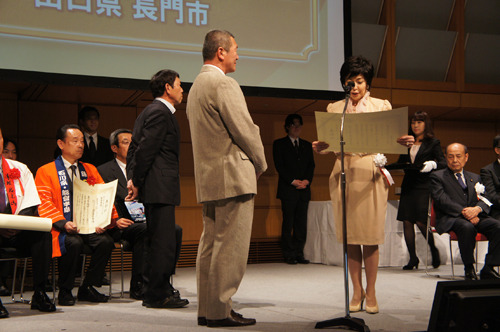 3月4日、東京国際フォーラムで女優の竹下景子さんから表彰状を受ける安森実行委員長