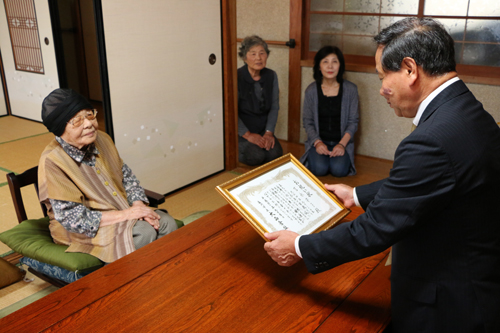 油谷後畑の吉永安子さんに、大西市長からお祝い状が手渡される