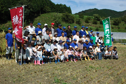 田んぼでの記念写真を撮るツアー一向