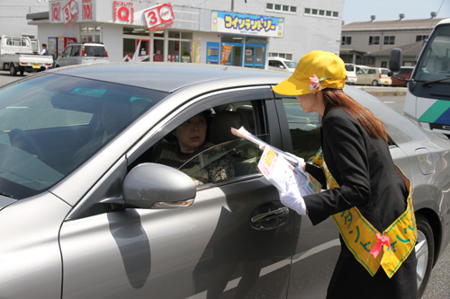 交通安全アテンダントもグッズを手渡す