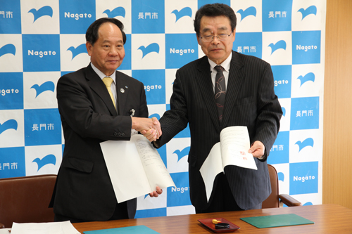協定を締結し握手する有吉会長（右）と大西市長