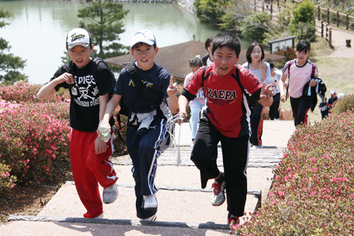 菅無田公園のツツジの間を歩く参加者