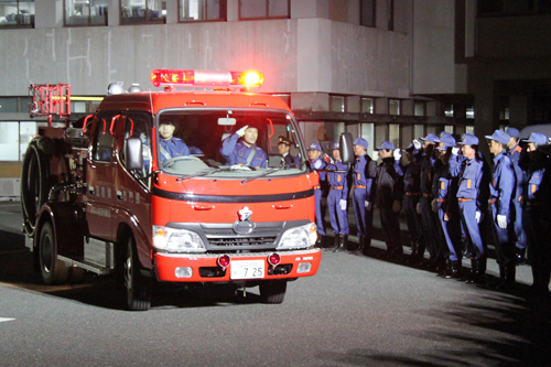 出動する消防車を見送る参加者