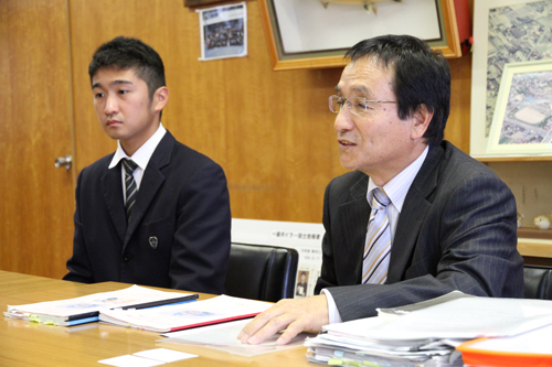 教科書と練習問題を手に話す藤本先生
