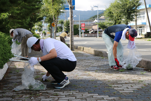 歩道の草取りやごみ拾いを行う