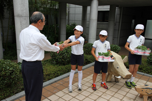 山田館長（左）にカランコエの花を手渡す