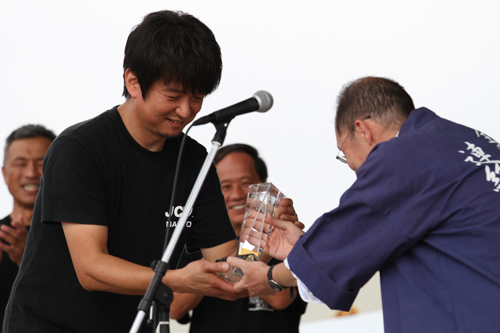 全国やきとり連絡協議会からトロフィーを受け取る大会副実行委員長の河村誠治さん