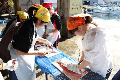 地元住民に教わりながら魚をさばく