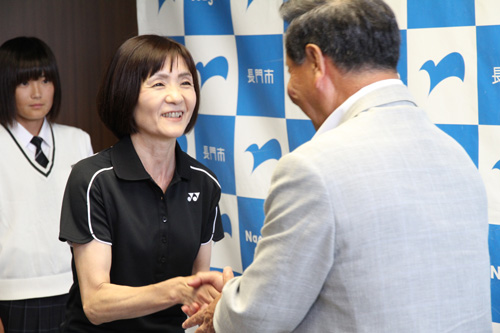 激励費が手渡され、大西市長と握手を交わす