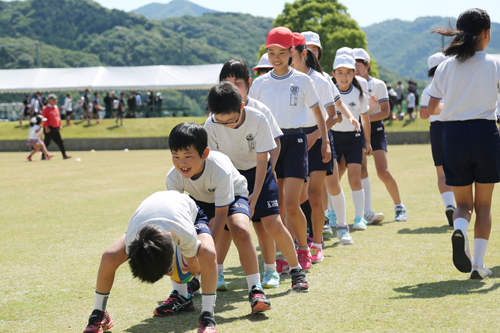 ラグビーボールをリレーで運び、ボールに親しむ参加者