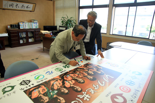 サインボードに書き込む大西市長