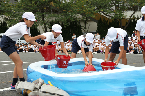 日置小学校の児童も水バケツでの消火活動を体験した
