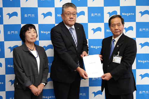 長門市行政改革懇話会の中原会長（中央）と小林副会長（左）が、大西市長に提言書を手渡す