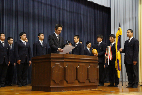 大津緑洋高校の原田治幸校長が、賞状やトロフィー、優勝旗などを披露