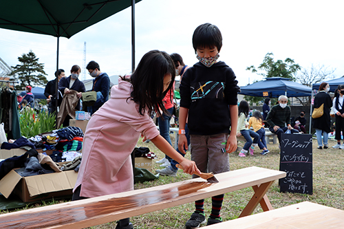 ベンチづくりのワークショップでペンキを塗る子どもたち