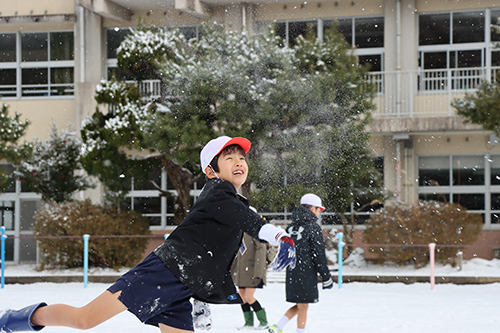 積もったばかりの雪で遊ぶ子どもたち