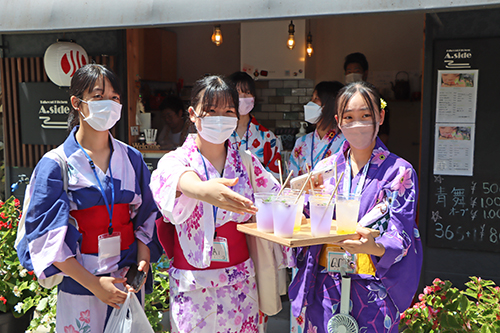 大津緑洋高校の生徒が冷たい飲み物を手渡し