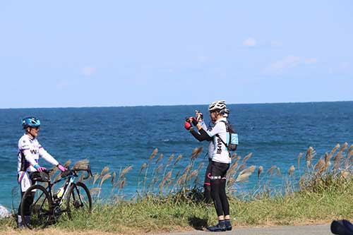 油谷大浜海水浴場をバックに撮影する参加者