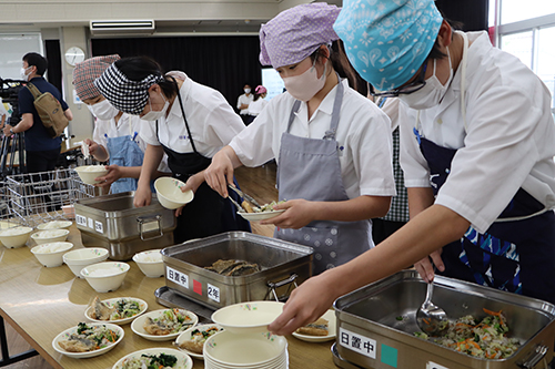 給食当番がお皿に盛りつける