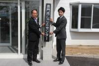 長門市しごとセンターの看板を掲げる大西市長と岡藤理事長
